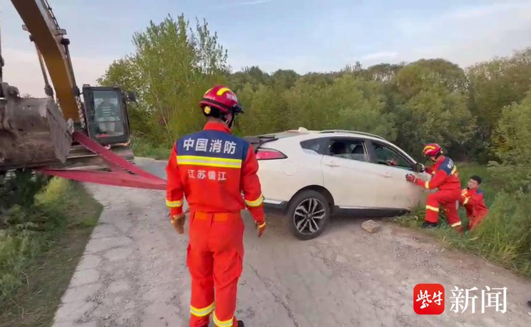 路况不明轿车被困江堤 消防喊来挖土机拖车救人