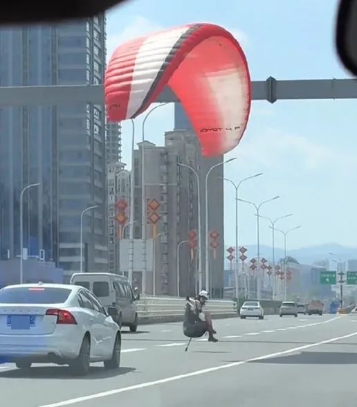 现实版"吃鸡"！女子乘降落伞"空降"大桥中央，车辆紧急避让…