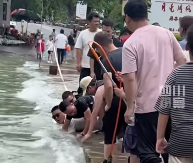 男孩跌入湍流被吸入桥洞！白衣大哥眼疾手快抓住男孩，众人合力拽回