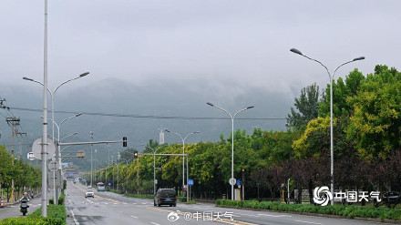 北京降雨断断续续 城区地面难干郊区雾气朦胧
