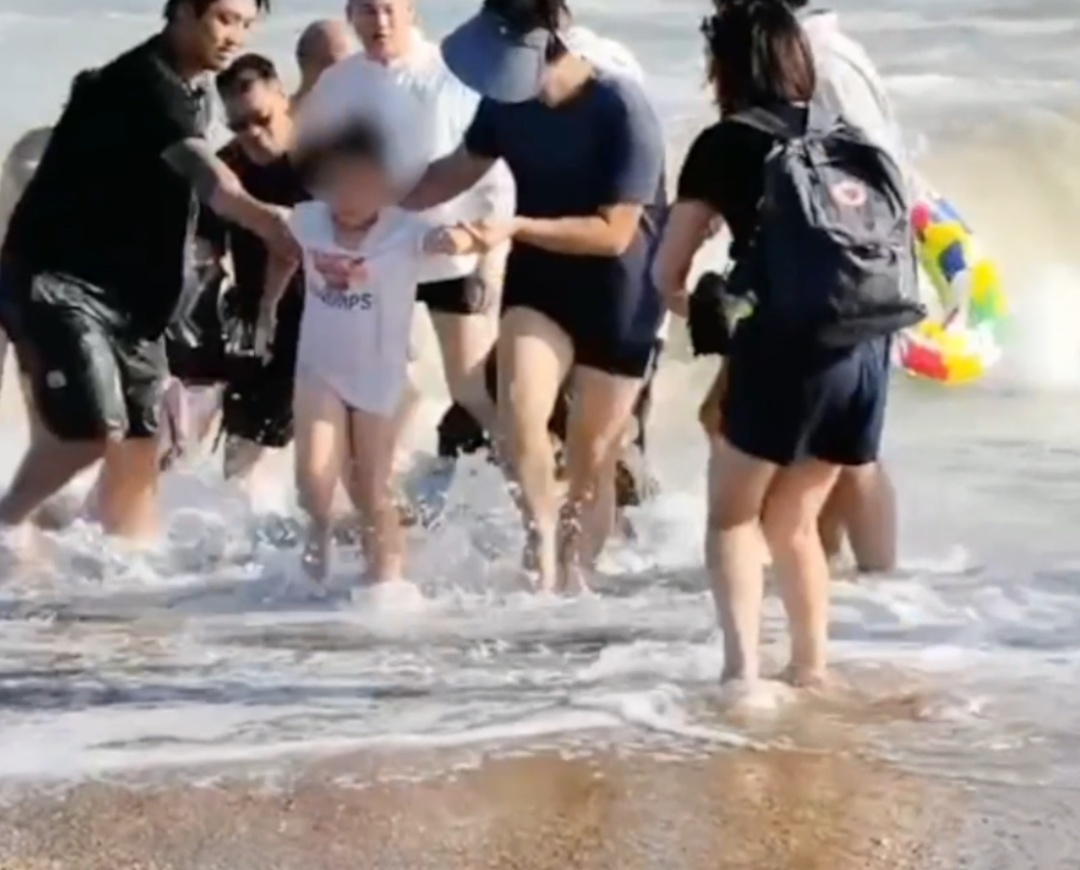 小孩被卷入海浪无法起身，危急时刻一男子奋不顾身跃入海中→