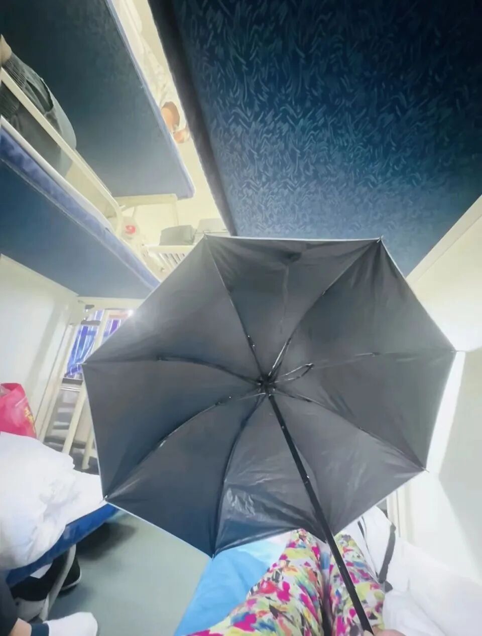 女生躺火车卧铺打伞遮隐私，“过道坐着两名陌生男乘客”，12306回应