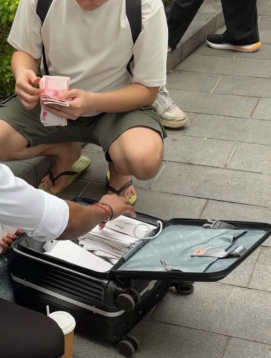 iPhone17线下开售首日，有人用旅行袋装大叠现金现场交易