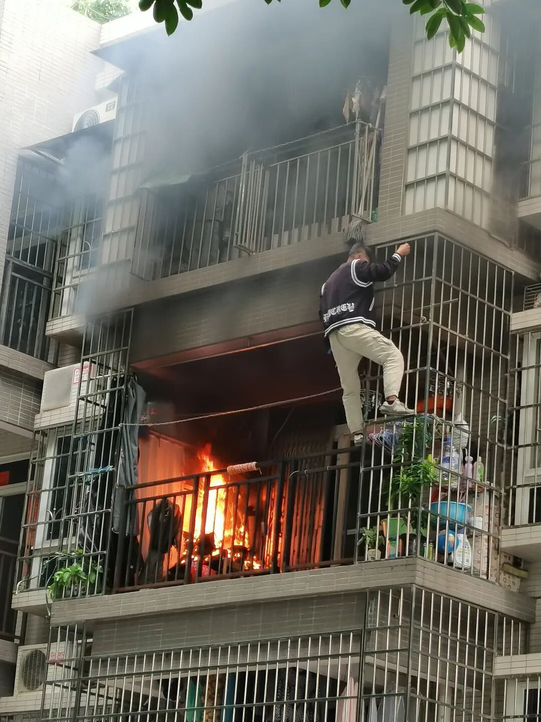 阳台突然着火，屋主不在！广州一社区干部徒手爬楼救火！