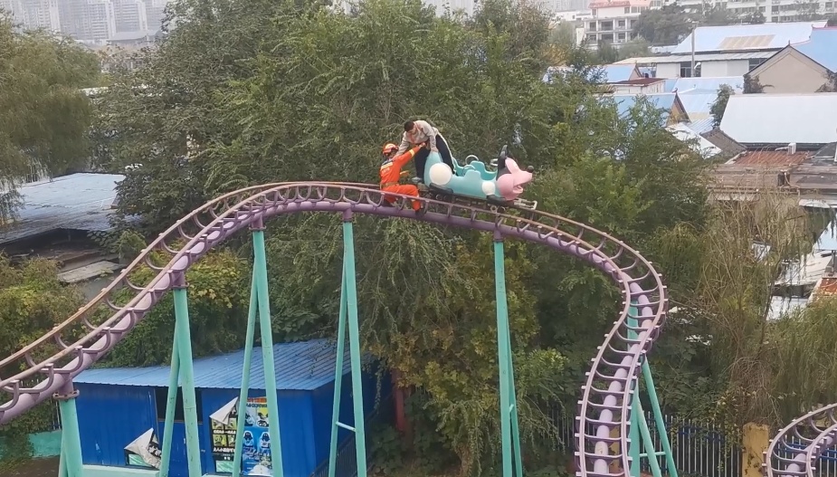 游乐场惊魂！过山车下落时突停，男孩被困10米高空