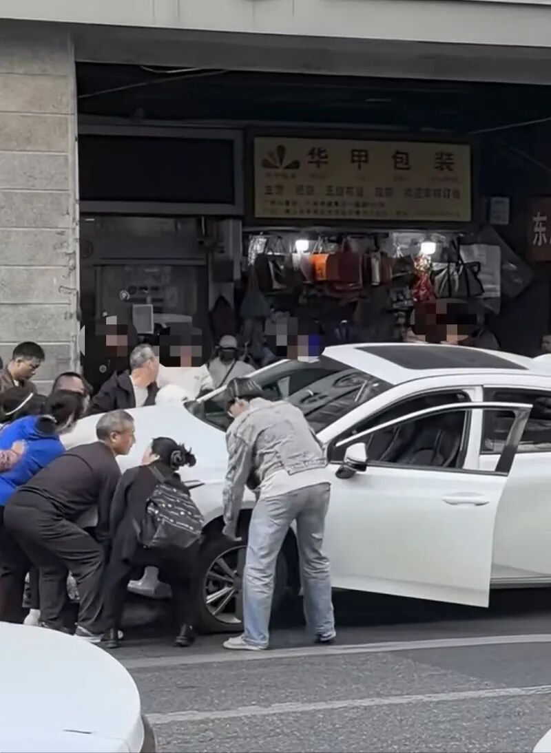 广州街头一女子被压车底，一群路人合力抬车救人
