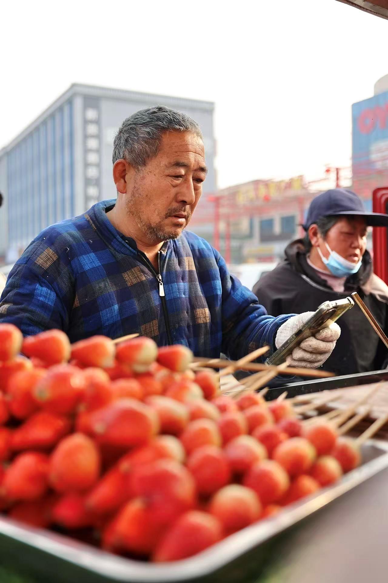寒风中排长队买大爷糖葫芦 为啥有人光给钱不拿走?