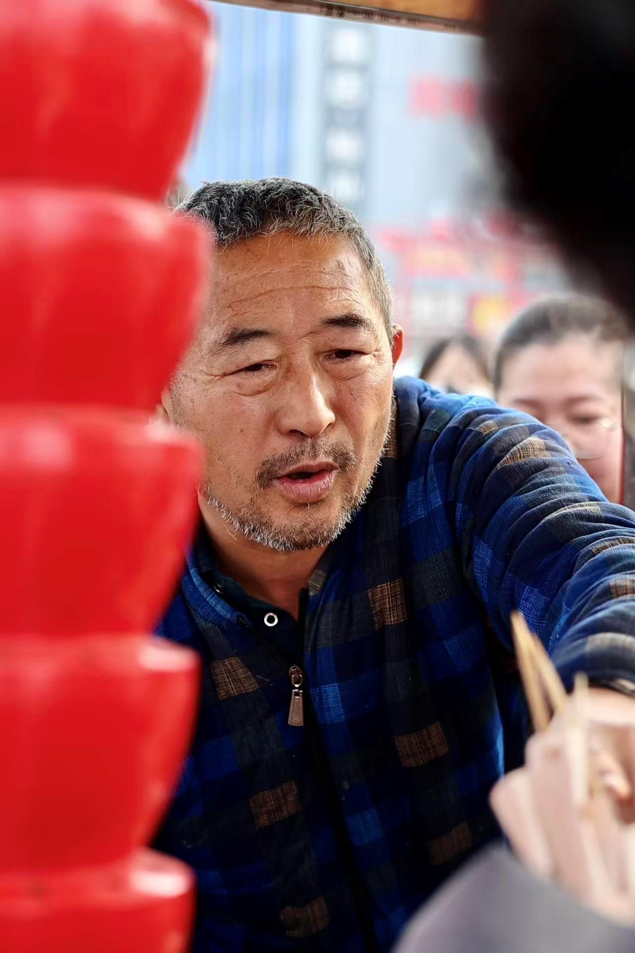 寒风中排长队买大爷糖葫芦 为啥有人光给钱不拿走?
