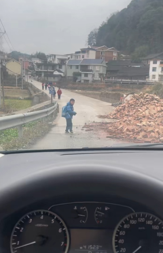 湘西一车主停车让路遇到暖心一幕：小男孩主动清理路上散落碎石，已买好零食送他