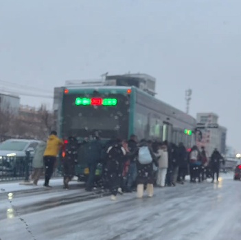 公交车雪中打滑，车上的乘客自发下车，集体推车前进