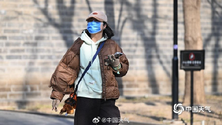 北京气温冲上12度创今年来新高 街头市民棉服穿不住