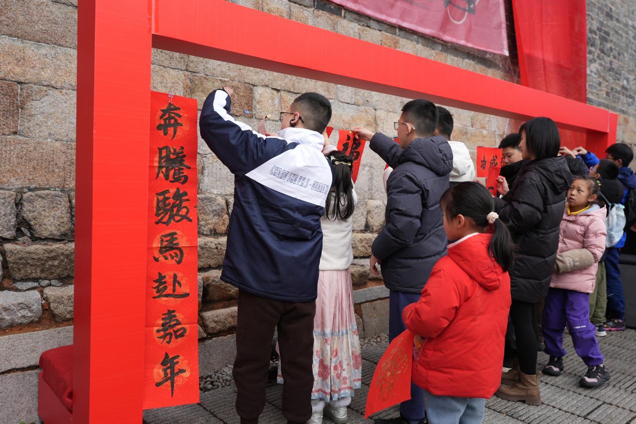 巨幅春联“爬”上长沙地标 传统民俗焕新星城年味 巨幅春联“爬”上长沙地标 传统民俗焕新星城年味