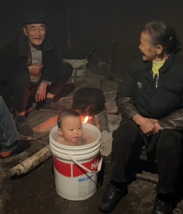 太爷爷一句想你了，一岁半萌娃随父母跨越三百公里回村，网友：烤火洗澡就像自己小时候