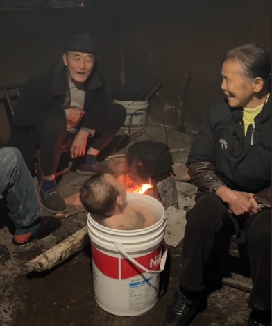 太爷爷一句想你了，一岁半萌娃随父母跨越三百公里回村，网友：烤火洗澡就像自己小时候