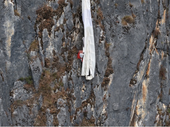 翼装飞行者挂悬崖5小时获救，有网友称应收费，昆明警方回应