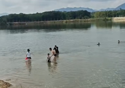 两小孩河边玩耍不慎落水，一青年跟着跳水却深陷险境，露营市民纵身一跃....