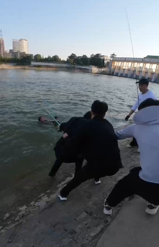 周口男孩意外落水，黑衣“小辫哥”下水救人，目击者：钓鱼捞最终合力用鱼竿拉两人上岸