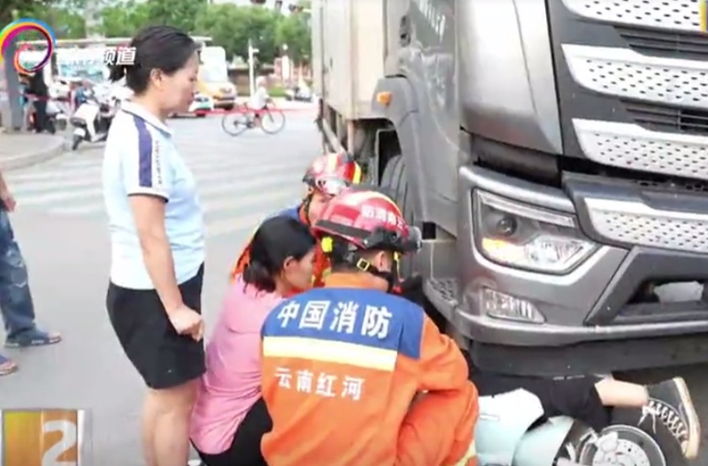 揪心！货车右转酿祸，女子连人带车卡底盘