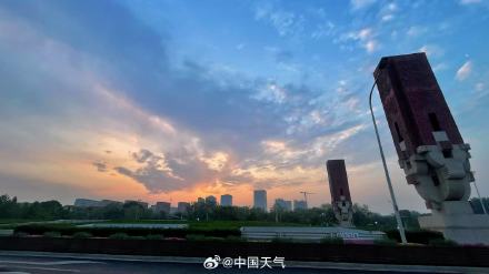 北京薄雾中亮起淡粉朝霞