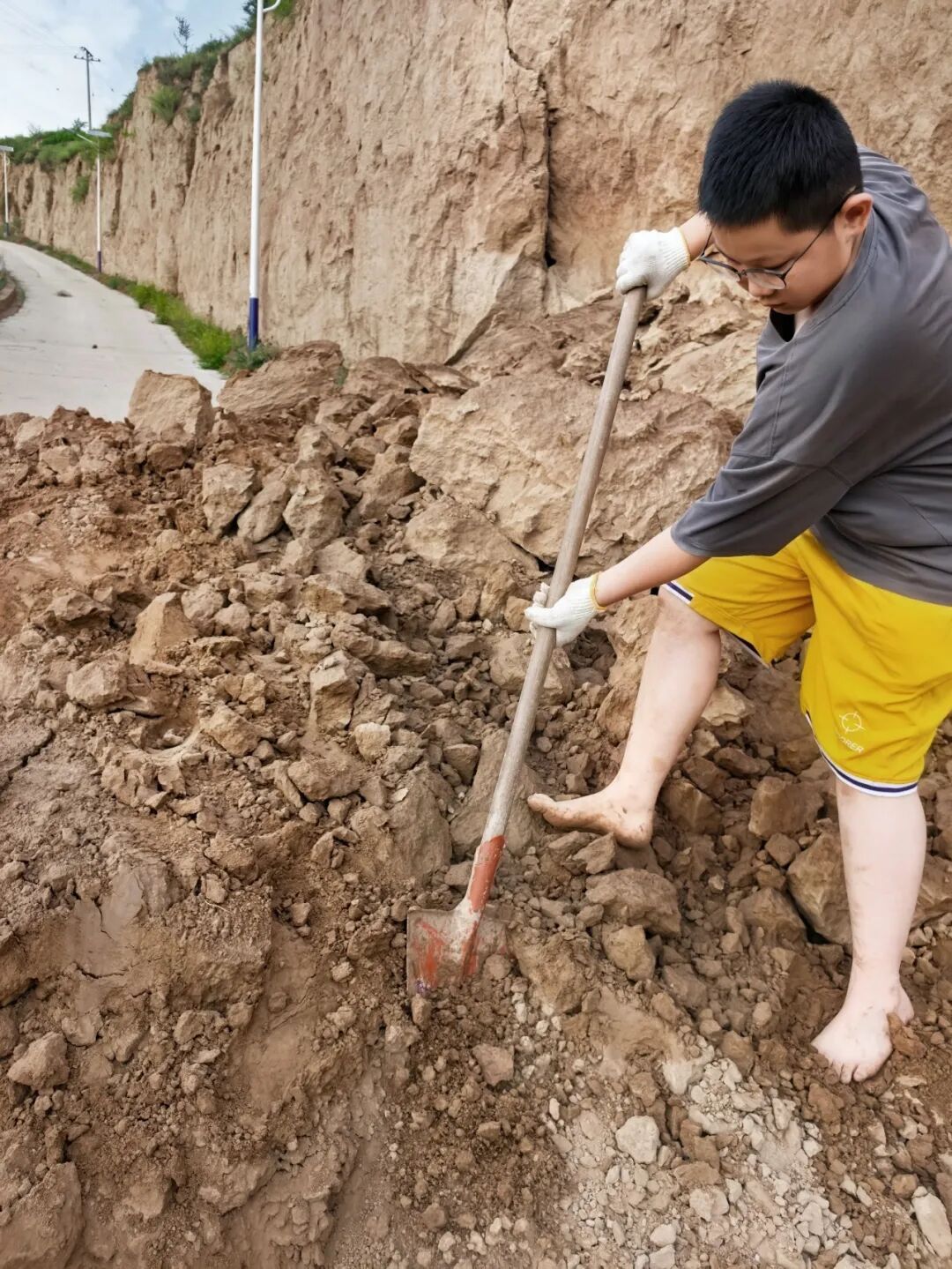 陕西榆林一驻村队员带13岁儿子赤脚清理塌方村路，队员：看到了孩子身上其他闪光点