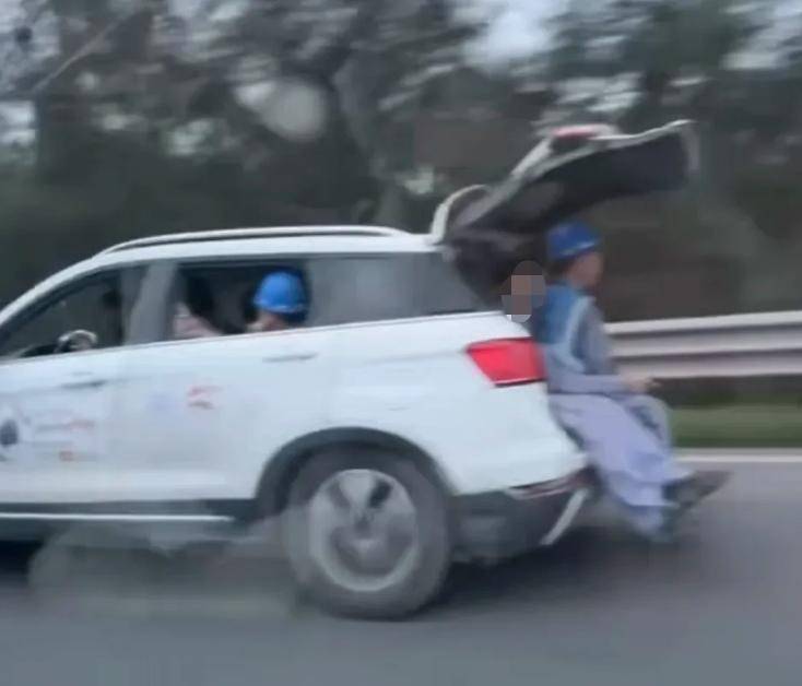 又见行驶中车辆后备厢打开坐人!疑似车内满员,多出2人后备厢内“加座” 又见行驶中车辆后备厢打开坐人!疑似车内满员,多出2人后备厢内“加座”