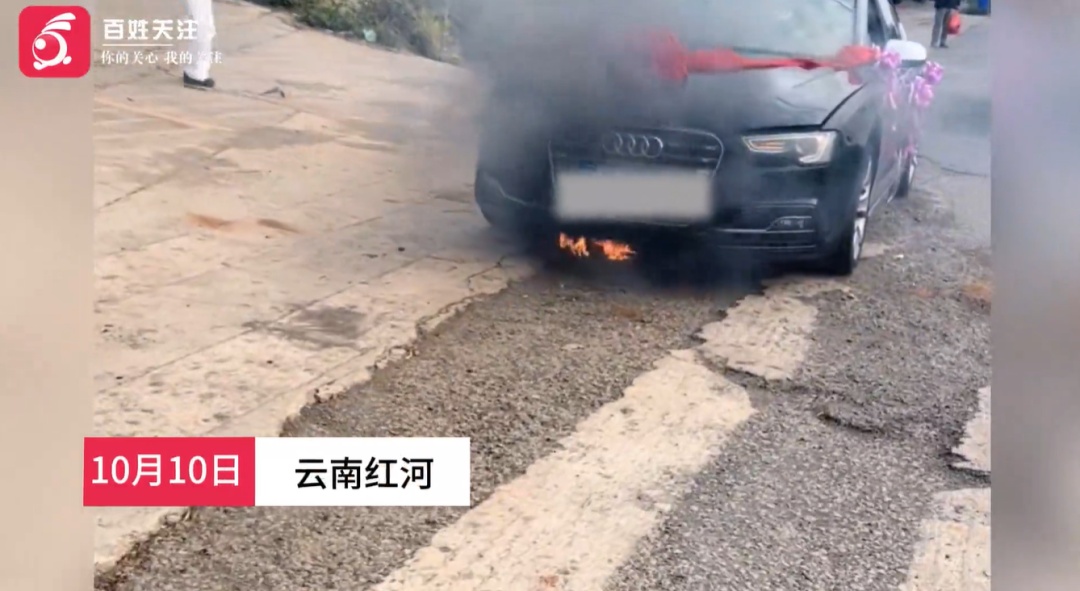 云南一辆奥迪车接亲时突发自燃，车底冒出明火，众人合力扑救，无人受伤