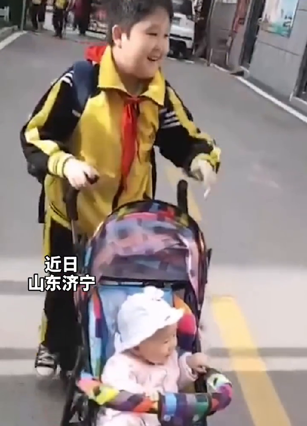 哥哥推婴儿车向同学炫耀妹妹：看！这是我的妹妹，可爱不？