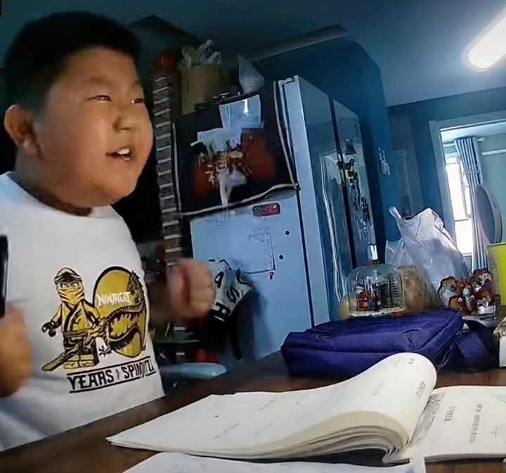 男孩写作业犯困，握拳默念“奥利给”为自己加油！