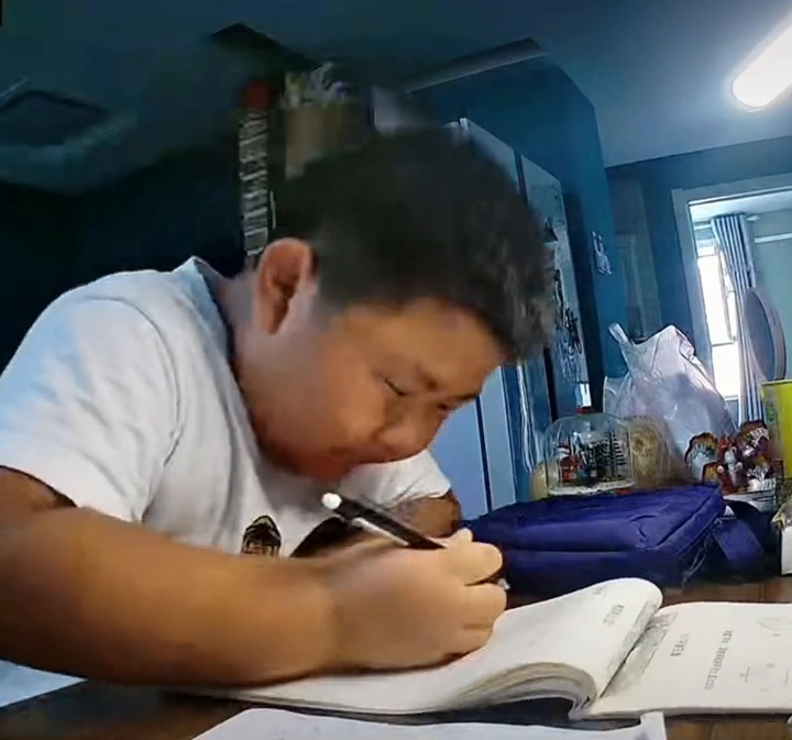 男孩写作业犯困，握拳默念“奥利给”为自己加油！